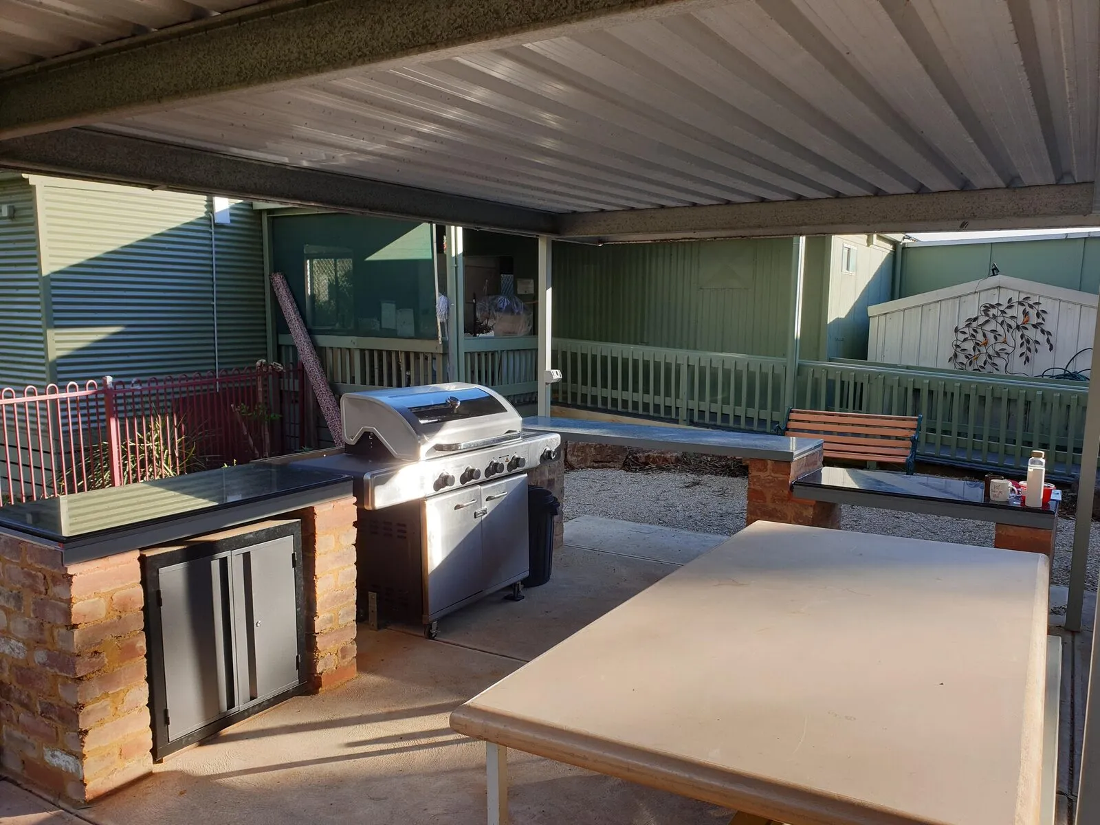 The covered barbecue area with a large barbecue, preparation bench and outdoor seating