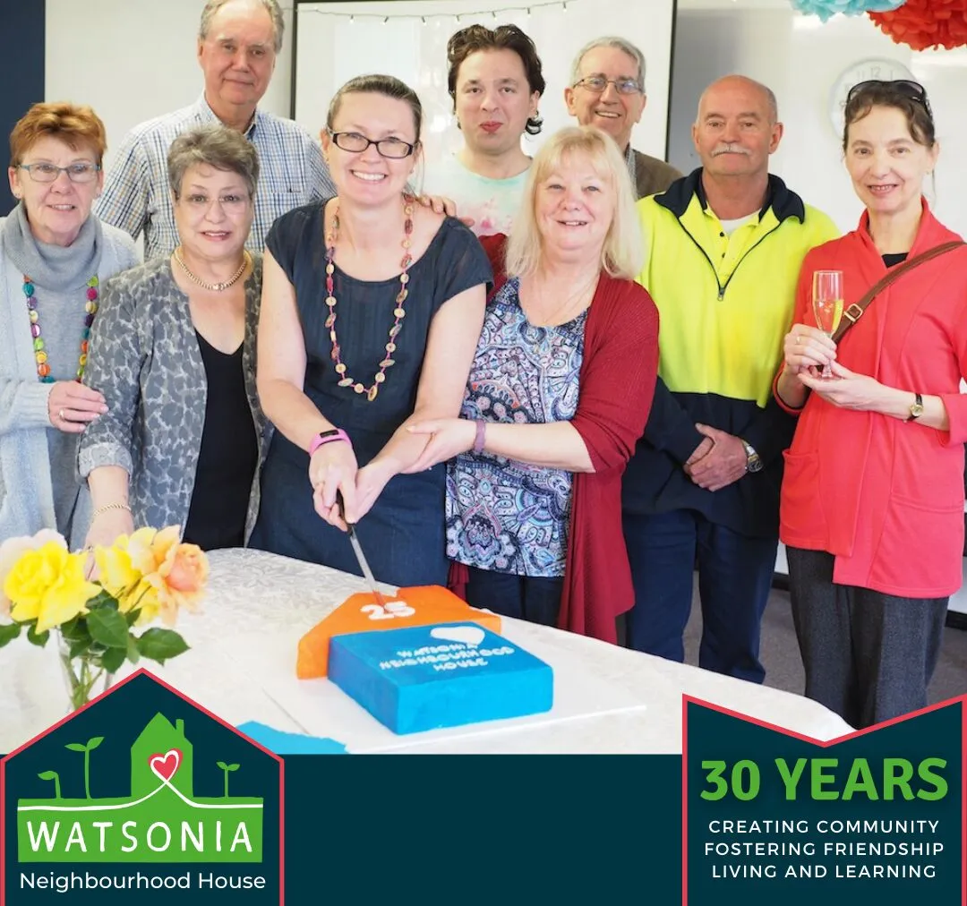 Staff and committee members gathered around a cake at the 30th birthday celebration
